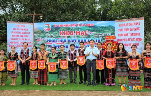 Lãnh đạo xã Tây Giang tặng cờ lưu niệm cho các đơn vị tham gia lễ hội. Ảnh: ALĂNG NGƯỚC