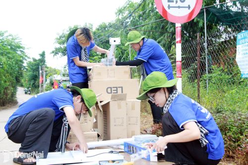 Sinh viên tình nguyện Trường đại học Công nghệ Miền Đông lắp đặt đèn năng lượng mặt trời tại ấp Phú Vinh, xã Phú Vinh.