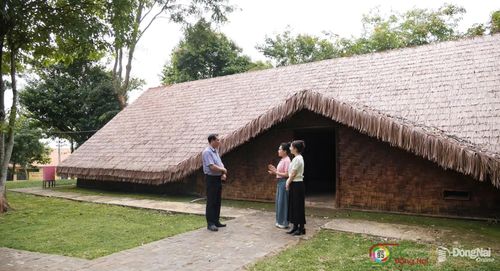 Ông Phạm Anh Tuấn, Giám đốc Trung tâm Dịch vụ tổng hợp xã Bom Bo, giới thiệu giá trị kiến trúc và không gian văn hóa dưới mái nhà dài truyền thống của đồng bào Xtiêng. Ảnh: Tiến Dũng
