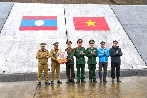 Trung tá Lê Viết Phương tặng quà Công an huyện Sa Mouay (Lào) tại cửa khẩu biên giới A Đớt.