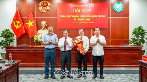 Phó Chủ tịch UBND tỉnh Nguyễn Minh Luân trao quyết định, tặng hoa đồng chí Từ Hoàng Ân và chụp ảnh lưu niệm cùng