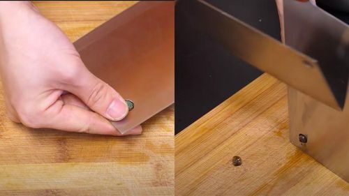 Sơ chế ốc bằng cách cố định dao lên thớt và dùng con dao khác để loại bỏ đuôi ốc.