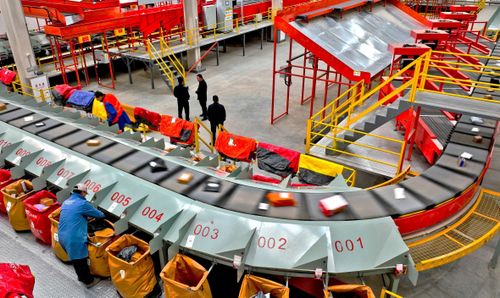 Các nhân viên của JD Logistics giám sát hệ thống phân loại bưu kiện tại tỉnh Cam Túc. Ảnh: VCG.