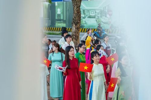 Hòa trong đoàn diễu hành là trang phục áo dài truyền thống của Việt Nam, thể hiện sự giao thoa văn hóa, hữu nghị, bền chặt giữa hai Quốc gia. (Ảnh: Thanh Phong/Vietnam+)