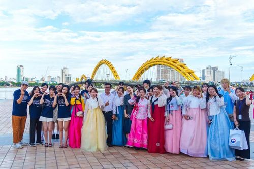 Các thành viên đoàn diễu hành chụp ảnh lưu niệm tại khu vực cầu Rồng. (Ảnh: Thanh Phong/Vietnam+)
