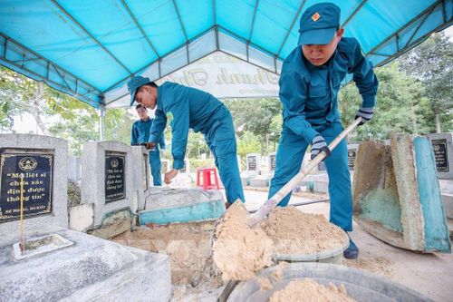 Các cán bộ, chiến sĩ cẩn trọng mở phần mộ theo đúng quy trình kỹ thuật để lấy mẫu hài cốt phục vụ giám định ADN. Ảnh: Giang Phương - TTXVN