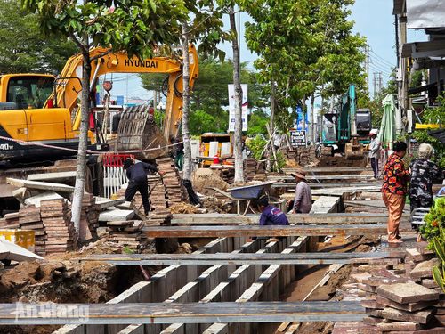 Đơn vị thi công huy động xe cơ giới và nhân lực lắp đặt hào kỹ thuật trên đường Phan Thị Ràng. Ảnh: THỤY DU