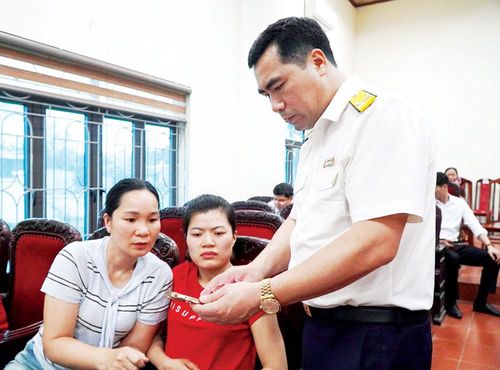 Cán bộ ngành Thuế hướng dẫn người dân xã Kép cài đặt, thao tác thủ tục về thuế trên môi trường mạng. Ảnh: Dương Uyên.