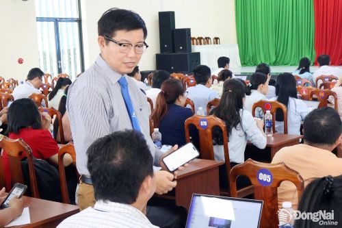 Đại diện Trường đại học Lạc Hồng hướng dẫn công chức, viên chức xã Đại Phước sử dụng phần mềm trợ lý ảo “AI công sở”. Ảnh: C.T.V