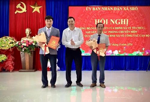Bí thư Đảng ủy, Chủ tịch HĐND xã SRó Trần Văn Cửu (giữa) trao Nghị quyết của HĐND xã về tổ chức, sắp xếp lại các phòng chuyên môn thuộc UBND xã. Ảnh: M.P