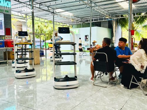 Du khách thích thú theo dõi và ghi lại khoảnh khắc robot phục vụ mang món đến bàn.