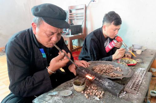 Hai cha con ông Lù Văn Kim và anh Lù Văn Nghiêm cùng thực hiện công đoạn nung bạc, đòi hỏi sự chính xác để sản phẩm đạt độ bền và màu sắc đẹp.