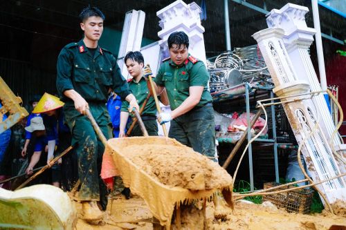 Thanh niên Công an Sơn La triển khai lực lượng hỗ trợ nhân dân nạo vét bùn đất.
