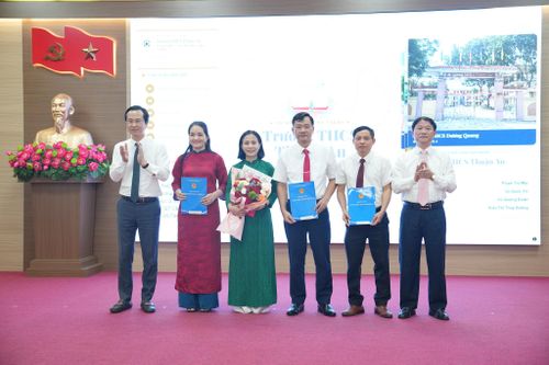 Bí thư Đảng ủy, Chủ tịch HĐND xã Thuận An Trương Văn Học và Chủ tịch UBND xã Thuận An Nguyễn Tuấn Khanh trao quyết định tới Ban Giám hiệu Trường THCS Thuận An. Ảnh: Vân Thư