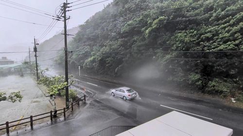  Một chiếc ôtô di chuyển dưới mưa lớn và gió mạnh khi bão Dolphin tiến vào đảo Amami, tỉnh Kagoshima. Ảnh: Reuters. 