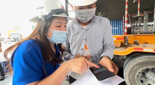 Nhân viên Cảng Tân Cảng - Cát Lái hướng dẫn khách hàng sử dụng chứng từ giao dịch điện tử trong giao nhận container. Ảnh: GIA HIẾU