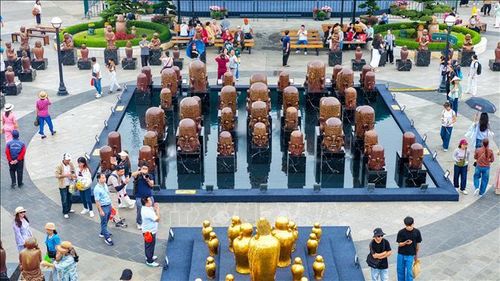 Du khách trải nghiệm tham quan tại Triển lãm “Kinh gốm – Thanh âm thế gian” của nghệ sỹ Nguyễn Tuấn (Tuấn Gốm) tại Khu du lịch Sun World Ba Den Mountain. Ảnh: Minh Phú/TTXVN