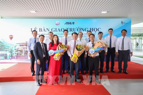 Lãnh đạo Trường Trung học cơ sở Nguyễn Thái Học và Trường Tiểu học Duy Tân nhận chìa khóa, chính thức tiếp nhận và đưa hai công trình vào sử dụng. Ảnh: Giang Phương - TTXVN