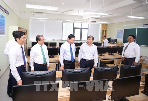 Các đại biểu tham quan một phòng học được đầu tư trang thiết bị đồng bộ tại Trường Trung học cơ sở Nguyễn Thái Học. Ảnh: Giang Phương - TTXVN