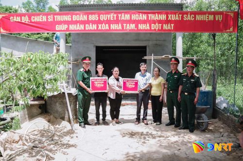 Lãnh đạo Bộ Chỉ huy Quân sự thành phố tặng quà cho gia đình được hỗ trợ xóa nhà tạm, nhà dột nát trong chương trình tại xã Quế Sơn. Ảnh: Q.CƯỜNG