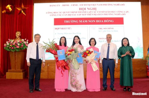 Lãnh đạo phường Nghĩa Đô trao quyết định thành lập Trường Mầm non Hoa Hồng. Ảnh: MT