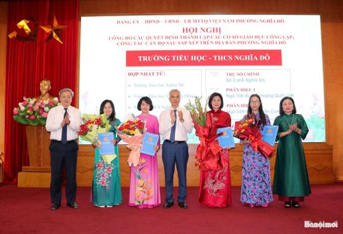 Lãnh đạo phường Nghĩa Đô trao quyết định thanh lập Trường Tiểu học - THCS Nghĩa Đô. Ảnh: MT