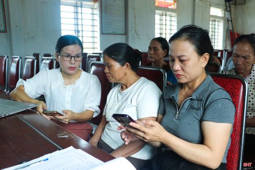Cán bộ xã Cẩm Xuyên trực tiếp hướng dẫn người dân thôn Vĩnh Phú (xã Cẩm Xuyên) thực hiện các thao tác trên môi trường số.