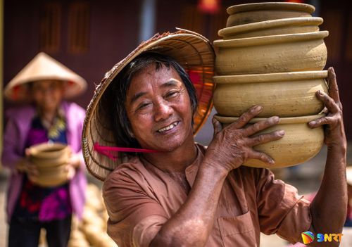 Người thợ làng gốm Thanh Hà nâng niu từng sản phẩm vừa hoàn thiện - thành quả của đôi tay và kinh nghiệm tích lũy qua nhiều thế hệ.
