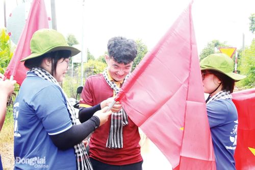 Cán bộ Đoàn, sinh viên Trường đại học Công nghệ Miền Đông tham gia chiến dịch tình nguyện Mùa hè xanh thực hiện tuyến đường cờ tại xã Phú Vinh.