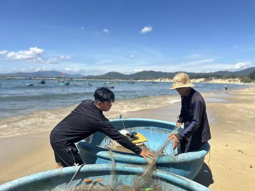  Hai ngư dân đang thau lưới sau một đêm hành nghề. Ảnh: Ngọc Quỳnh 