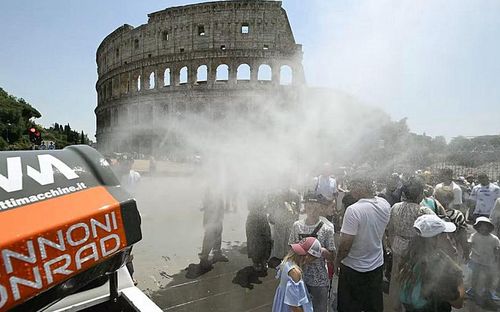 Lực lượng Bảo vệ Dân sự Italy sử dụng xe phun sương, giúp khách du lịch hạ nhiệt trong đợt nắng nóng tại Rome gần Đấu trường La Mã, ngày 26/6. Ảnh: Andreas Solaro/AFP/Getty