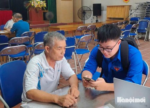 Đoàn viên Cao Duy Khánh trực tiếp hướng dẫn đảng viên đăng nhập, xác thực tài khoản trên Cổng Dịch vụ công của Đảng. Ảnh: Tuệ Lâm