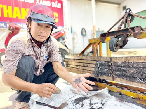 Ông Đinh Minh Cảnh phân loại số đinh và vật sắc nhọn hút được trên đường (Ảnh: NGUYỄN TÂN)