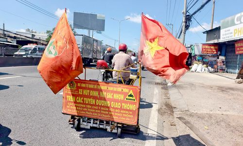 Ông Đinh Minh Cảnh điều khiển xe tự chế hút đinh trên đường Lê Khả Phiêu, công việc ông đã gắn bó hơn 20 năm qua (Ảnh: NGUYỄN TÂN)
