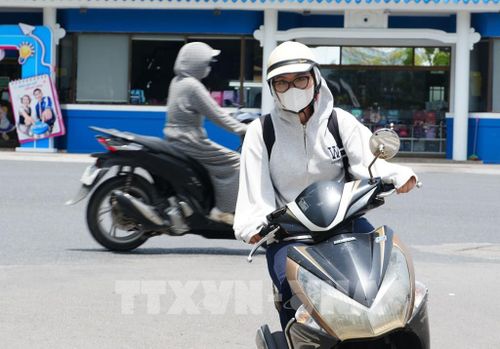 Người dân tham gia giao thông trên đường Trần Hưng Đạo, phường Phú Xuân, thành phố Huế, mặc đồ bảo hộ để giảm tác động nắng nóng. Ảnh: Nguyên Lý - TTXVN