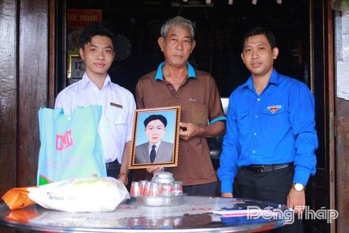 Đại diện Phường đoàn Mỹ Ngãi trao ảnh phục dựng liệt sĩ cho thân nhân liệt sĩ là ông Dương Hoàng Minh.