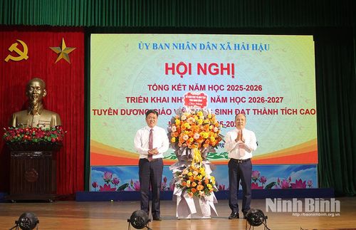 Đồng chí Nguyễn Văn Thuận, Phó Giám đốc Sở Giáo dục và Đào tạo tặng hoa chúc mừng thành tích xuất sắc của xã Hải Hậu trong năm học 2025-2026. Ảnh: Thành Trung