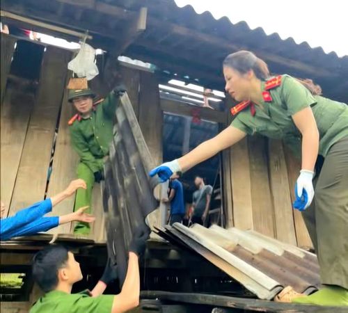 Công an xã Hưng Vũ giúp dân lợp lại mái nhà, khẩn trương khắc phục hậu quả mưa bão, ổn định cuộc sống.