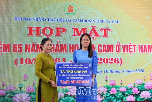  Bà Võ Thị Hồng Thoại, Chủ tịch Hội Nạn nhân chất độc da cam/dioxin tỉnh (bên trái), trao bảng tượng trưng kinh phí vận động tài trợ xây dựng cầu giao thông nông thôn cho phường Láng Tròn.