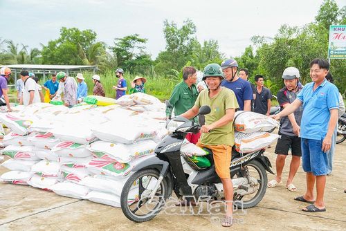Bà con nông dân phấn khởi nhận lúa giống.