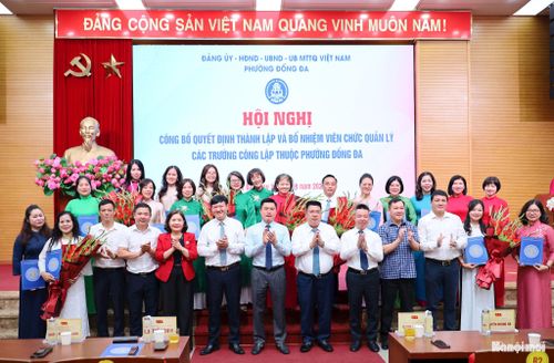 Lãnh đạo phường Đống Đa trao Quyết định và tặng hoa chúc mừng Ban Giám hiệu các trường sau sắp xếp. Ảnh: Hoa Thành
