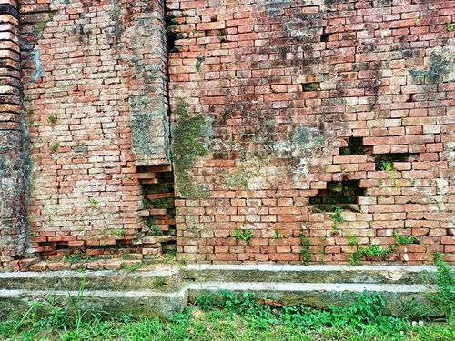 Một số lớp gạch dưới chân tường thành bị bong tróc.