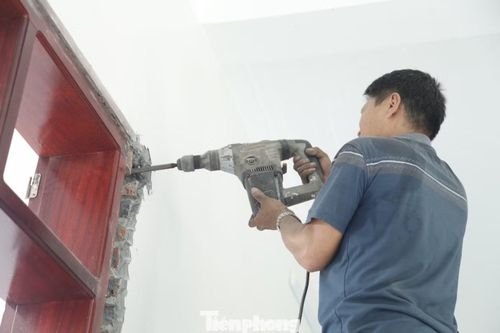Những người thợ đang tháo dỡ cửa nhà. Ảnh: Nguyễn Thắng.