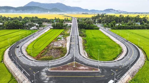 Những ngày nắng đẹp, bầu trời xanh cao, ánh nắng trải xuống mặt đường và những cánh đồng, phía xa ẩn hiện đồi núi.