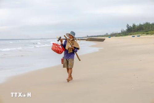 Sau chuyến biển xuyên đêm, người đàn ông vui vẻ thu dọn ngư cụ, chuẩn bị trở về nhà sau một đêm lao động trên biển. (Ảnh: Xuân Quý/TTXVN)