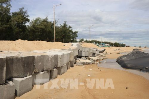 Các khối bê tông được sắp xếp phía ngoài tuyến đường, tạo thành hàng chắn sóng, giảm tác động trực tiếp của sóng biển vào chân đường. Ảnh: Mai Trang - TTXVN