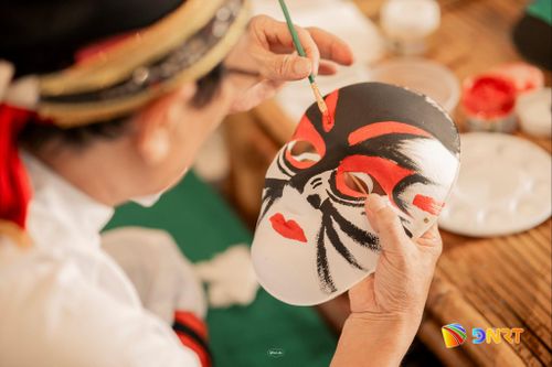 Du khách trải nghiệm vẽ mặt nạ tuồng. Ảnh: AHT