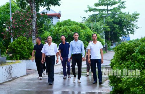 Anh Đỗ Tuấn Anh cùng cán bộ Tổ dân phố Đỗ Xá, phường Vị Khê kiểm tra tuyến đường nông thôn mới.