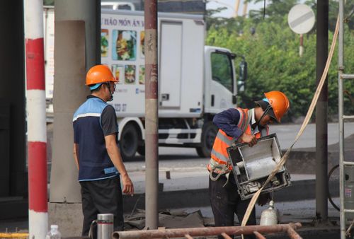 Công việc diễn ra ngay trên tuyến QL1 nên các khâu tháo dỡ được triển khai thận trọng, đảm bảo an toàn. Máy móc hoạt động liên tục bên trong công trường, trong khi bên ngoài, các phương tiện vẫn di chuyển qua tuyến đường.
