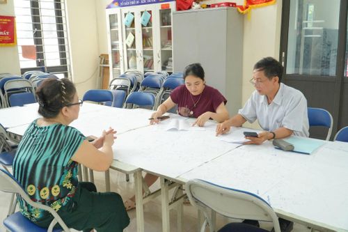 Ông Nguyễn Phi Đức, Tổ trưởng Tổ dân phố 22, trao đổi với người dân trong quá trình rà soát, cập nhật dữ liệu đất đai. Ảnh: Tùng Lâm.